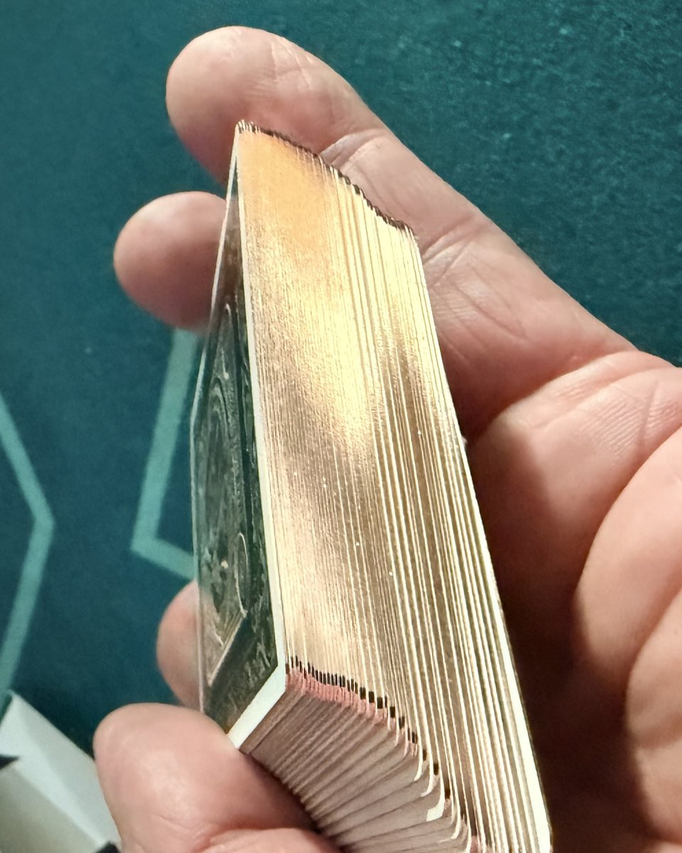 Close-up of a card stack showing the metallic gold-finished edges